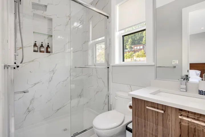 Bathroom featuring a marble finish shower and vanity