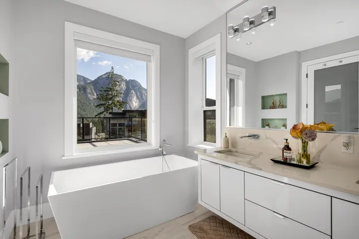 Bathroom with a freestanding tub, double vanity, a mountain view, and wood finished floors