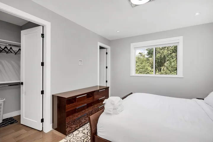 Bedroom with wood finished floors, recessed lighting, and a closet