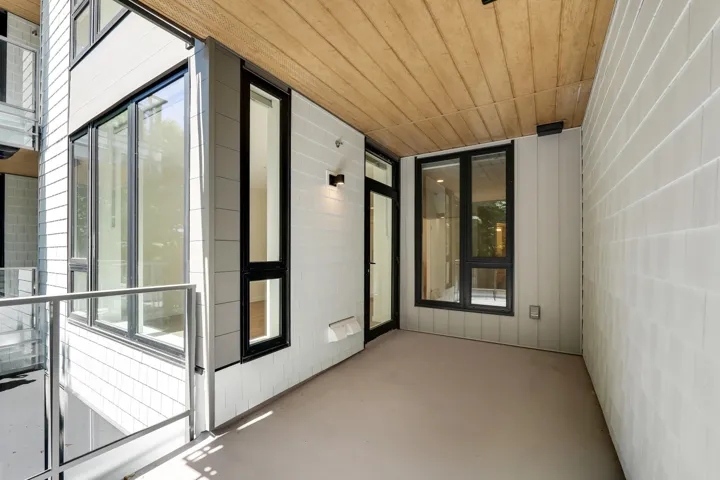 Private exterior patio featuring a wood-finish ceiling, light gray flooring, and white horizontal siding