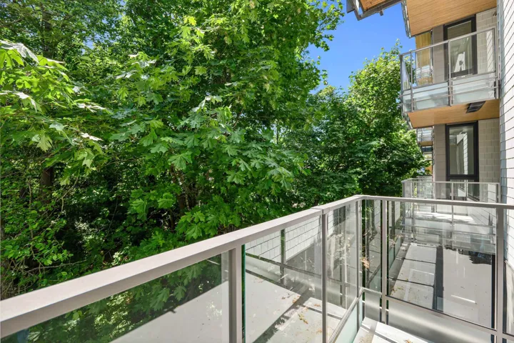 Balcony featuring glass panel railing, aluminum handrails, and a concrete surface