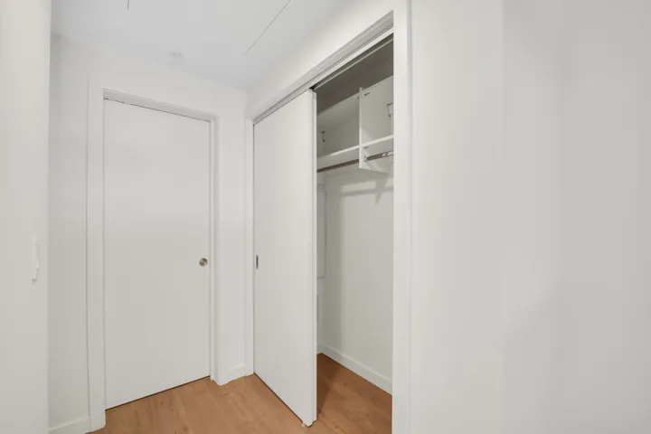 Hallway featuring a built-in closet with sliding doors and interior shelving