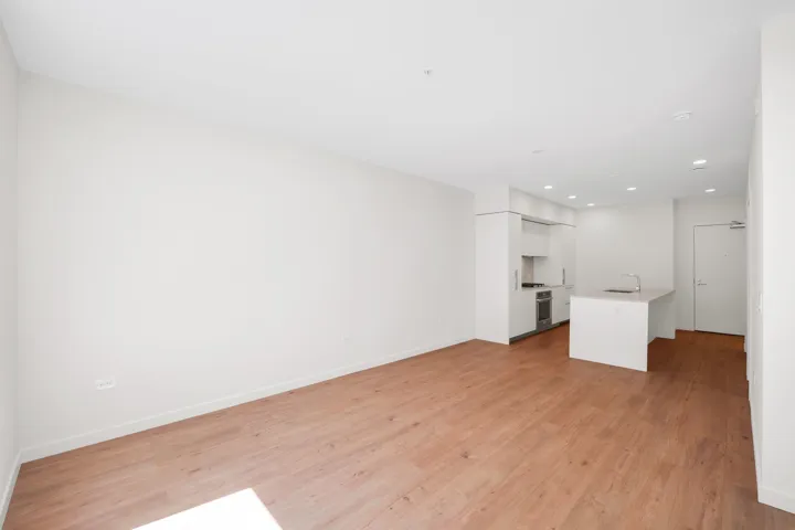 Open-concept living space featuring wood-finish flooring, recessed lighting, and a neutral color palette