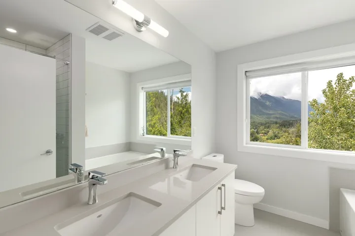 Full bath with toilet, a tub, baseboards, double vanity, and tile patterned flooring