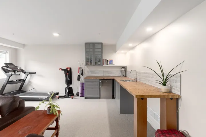 Indoor wet bar with refrigerator, light carpet, and recessed lighting