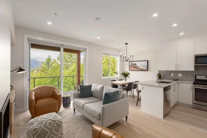 Living area with light wood finished floors, recessed lighting, and a chandelier