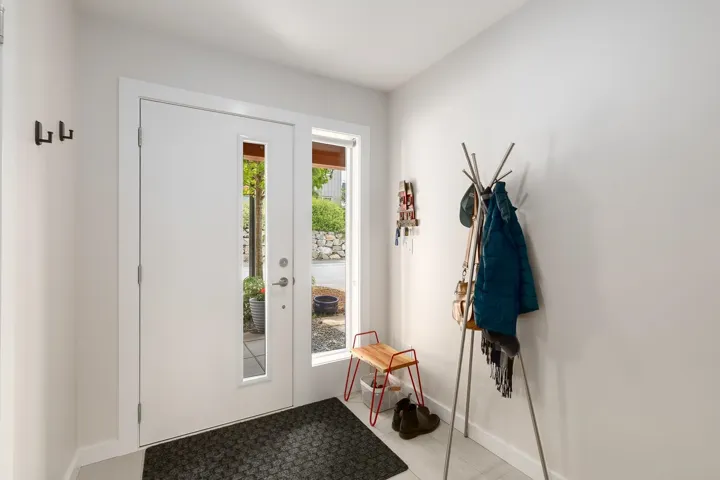 Entryway with light tile patterned floors and baseboards