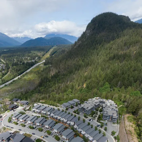 Aerial view of property's location featuring a heavily wooded area, mountains, and nearby suburban area