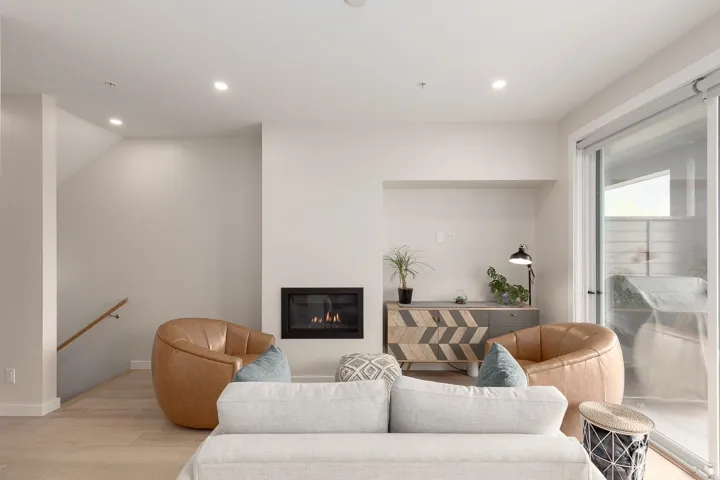 Living room featuring light wood-style floors, recessed lighting, a glass covered fireplace, and baseboards