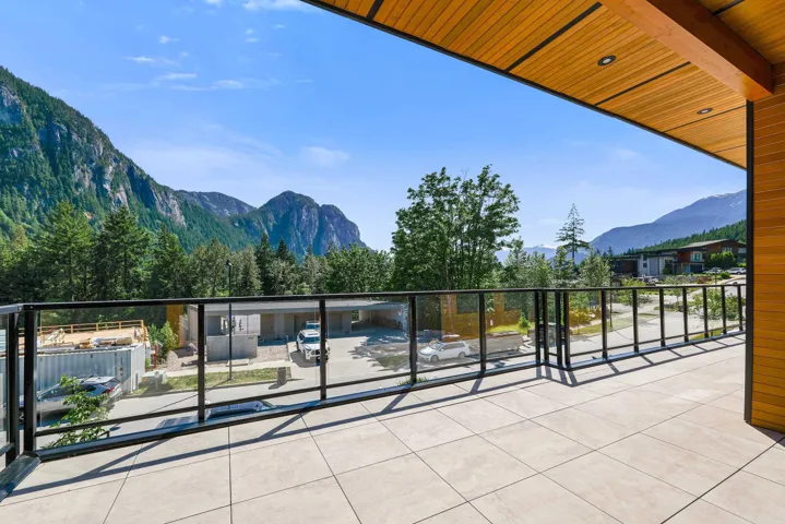 Spacious outdoor balcony featuring tile flooring and a glass railing system