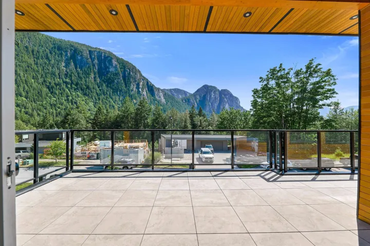 Outdoor patio featuring large format tile flooring and a glass railing with black frame