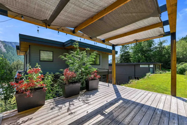 Wood-finish deck with a pergola featuring a retractable shade canopy and string lighting
