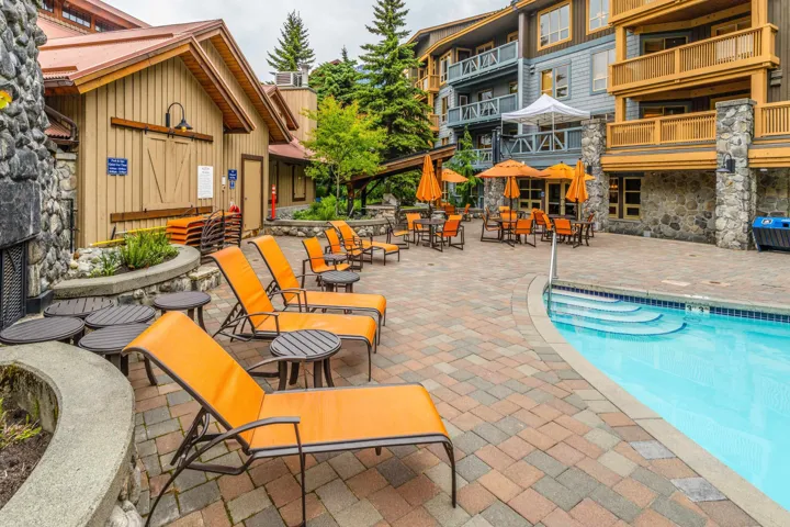 Community pool with a patio area and outdoor dining space