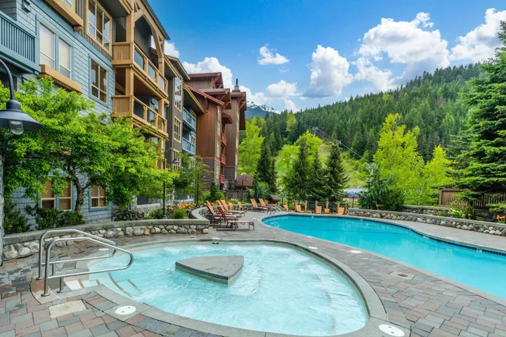 Community pool with a forest view and a patio