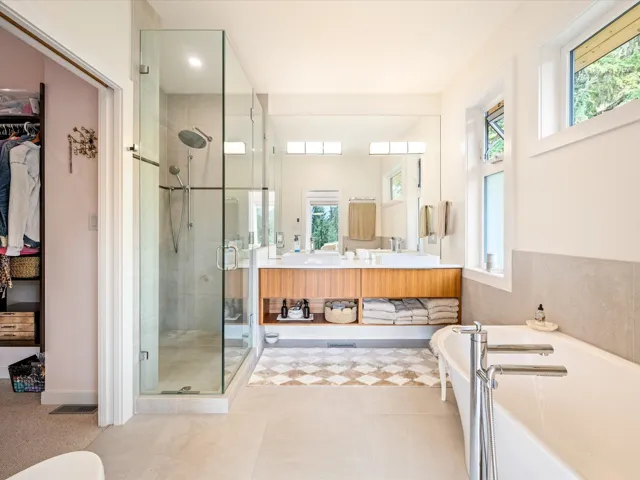 Full bathroom featuring a stall shower, double vanity, a freestanding tub, and a spacious closet
