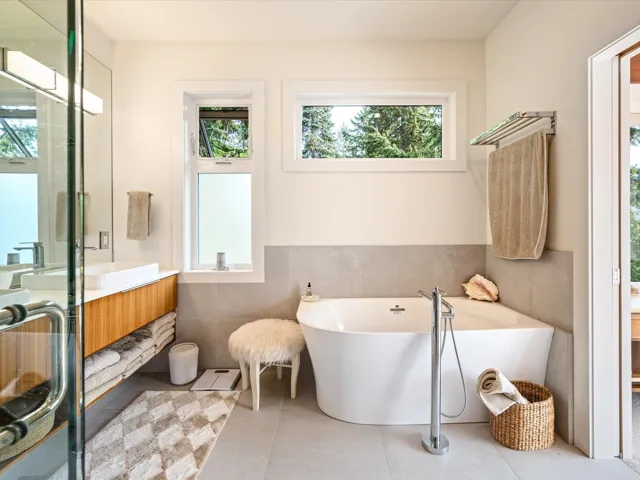 Bathroom featuring tile walls, vanity, a soaking tub, wainscoting, and light tile patterned flooring