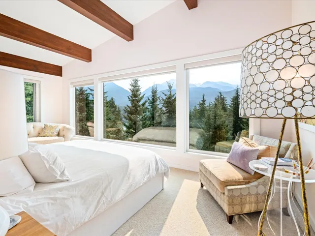 Carpeted bedroom with a mountain view and multiple windows