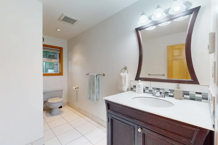 Vanity featuring a white countertop, undermount sink, and dark wood-finish cabinetry