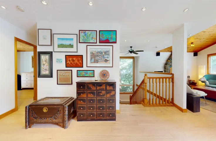 Light wood-finish flooring throughout, complemented by white walls and recessed ceiling lighting