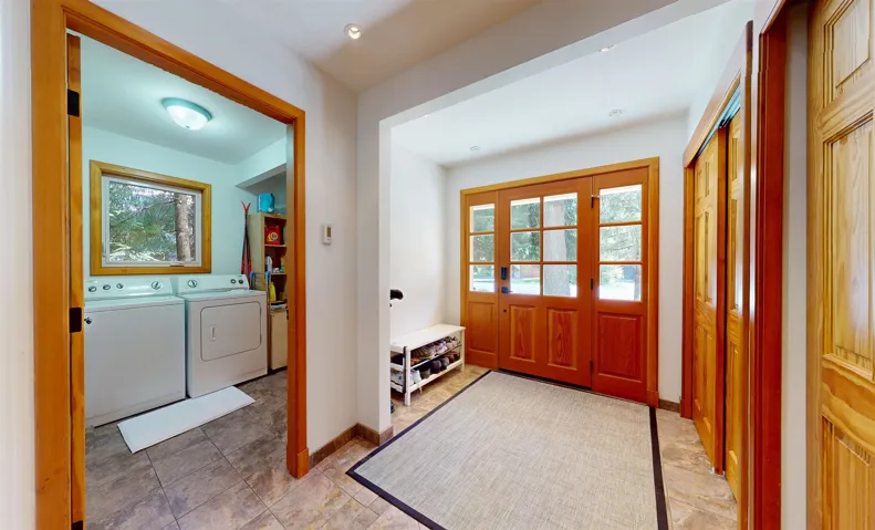 Entryway with a wood-finish front door featuring multiple glass panes, recessed lighting, and tile flooring