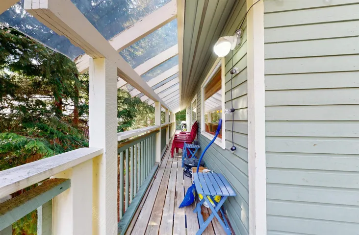 Covered outdoor deck with wood flooring and a clear panel roof
