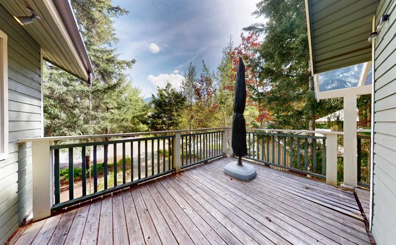 Expansive wood deck with a perimeter railing overlooking mature trees