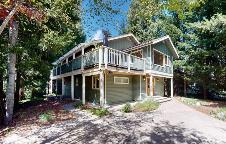 Multi-level exterior with green siding and white trim