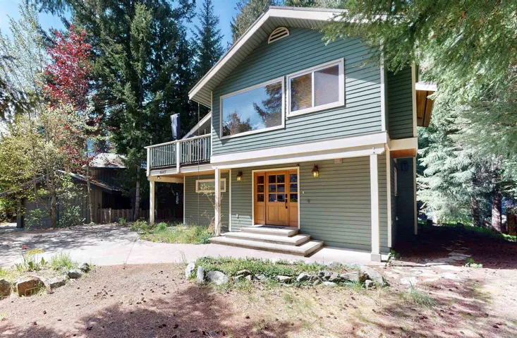Multi-level residence featuring green siding and a prominent upper-story balcony