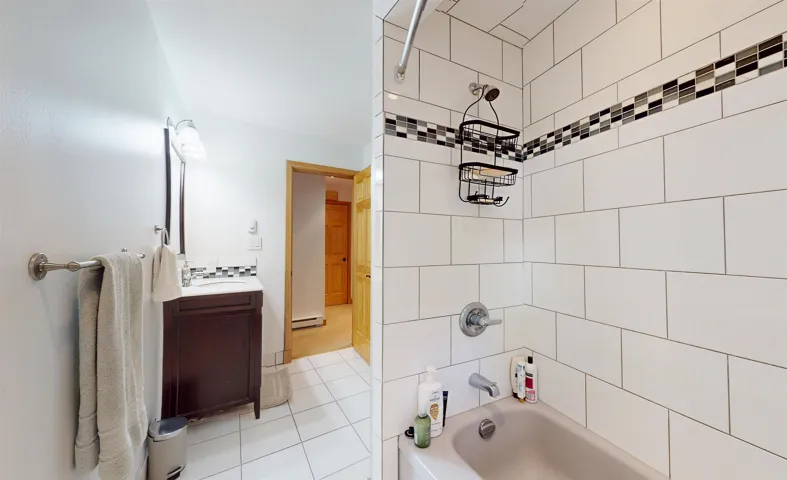 Bathroom featuring a dark wood-finish vanity with a mounted sink, mirrored medicine cabinet, and overhead light fixture