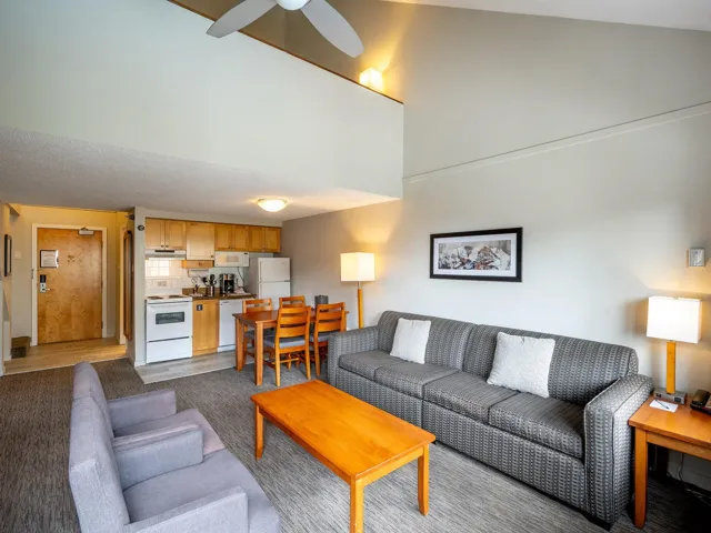 Living room featuring a ceiling fan and a towering ceiling