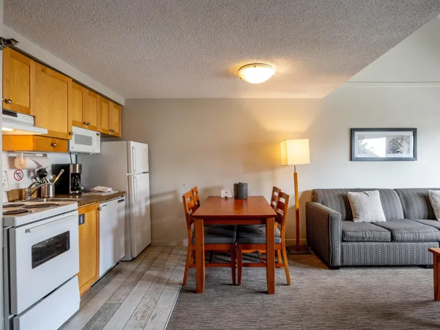 Kitchen featuring white appliances, open floor plan, extractor fan, a textured ceiling, and light wood-style floors