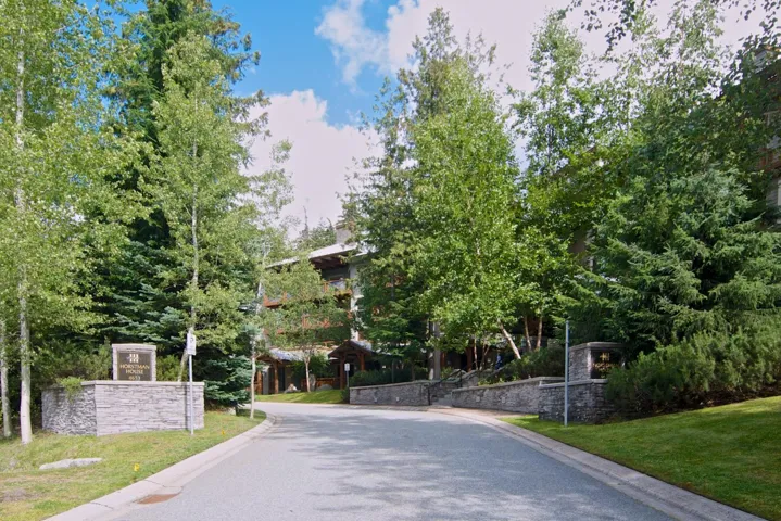 View of street featuring curbs and view of wooded area