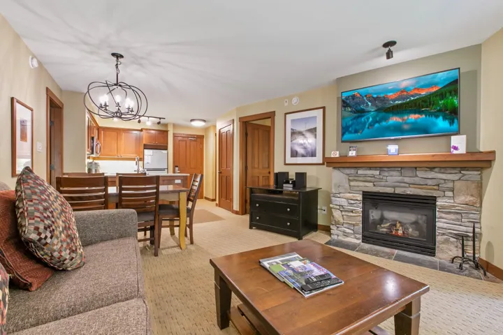 Living area featuring light carpet, a chandelier, and a fireplace