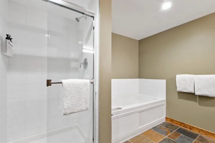 Full bathroom with a garden tub, a shower stall, and stone tile floors