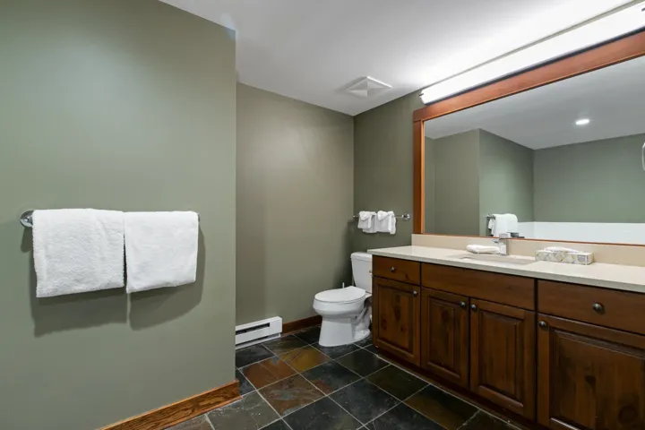 Half bath featuring vanity, a baseboard radiator, and stone tile floors