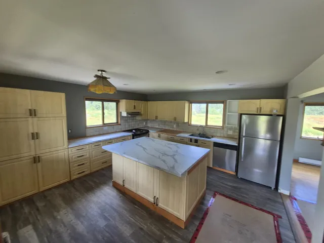 Kitchen featuring stainless steel appliances and light brown cabinets