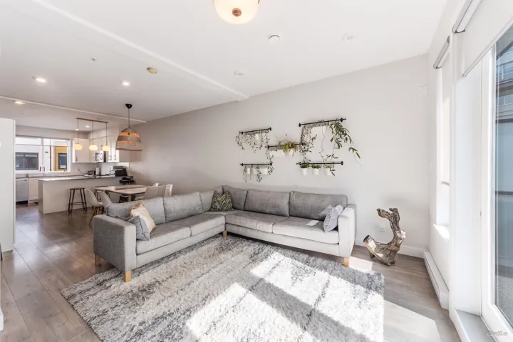 Living area with baseboard heating, light wood-type flooring, and recessed lighting
