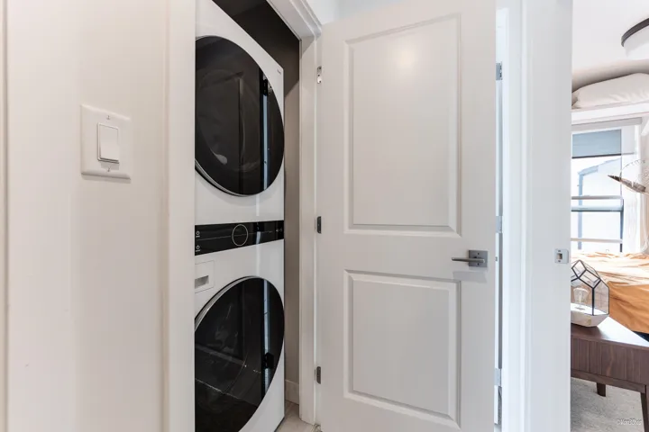 Laundry area featuring stacked washing machine and dryer