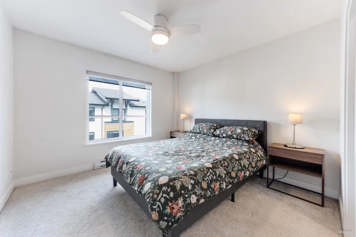 Bedroom with carpet floors, a ceiling fan, and a baseboard heating unit