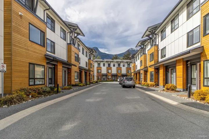 View of asphalt street with a residential view, a mountain view, and curbs