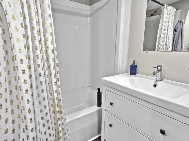 Full bathroom with shower / tub combo and vanity