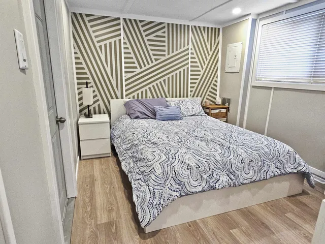 Bedroom featuring wood finished floors and baseboards