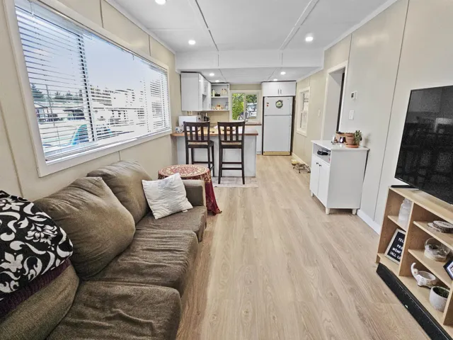 Living area with light wood-type flooring and recessed lighting