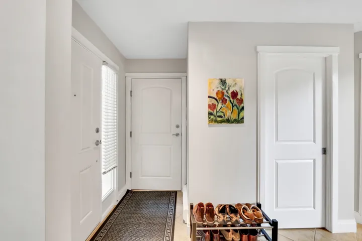 Entryway featuring white paneled doors, light grey wall tones, and a tiled floor