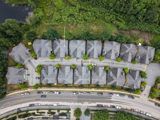 Residential community featuring multiple detached and attached structures with gray shingle roofs