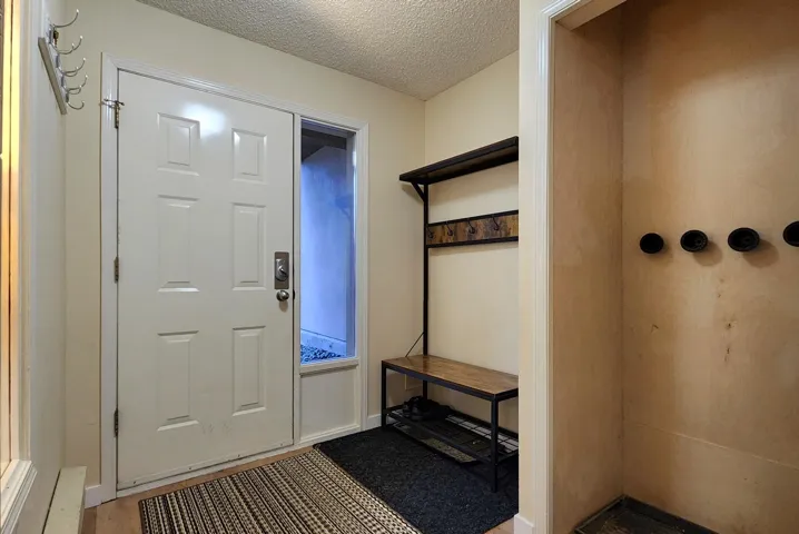 Entrance foyer with a textured ceiling and wood finished floors
