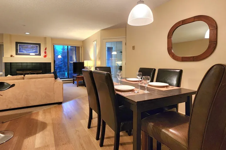 Dining space featuring a tile fireplace, light wood-style floors, and a textured ceiling