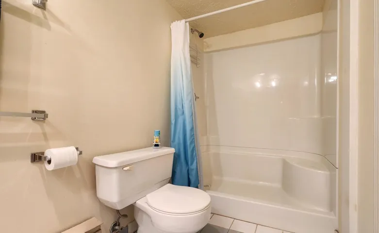 Bathroom featuring a stall shower, tile patterned flooring, and a textured ceiling