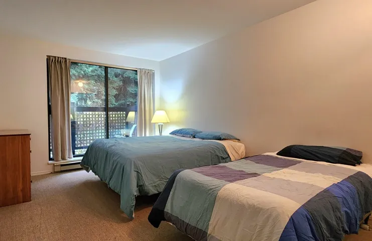 Carpeted bedroom featuring a baseboard radiator and baseboards