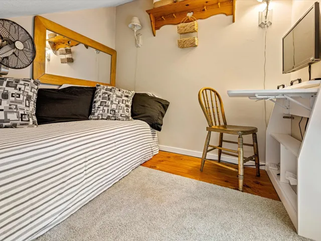 Bedroom with light wood-style flooring and light colored carpet